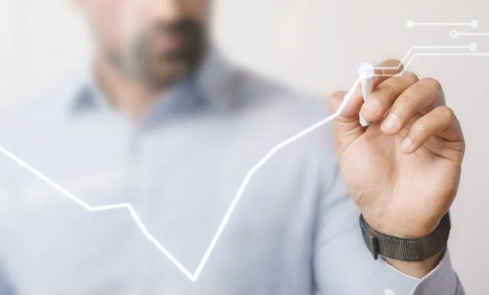 Hombre dibujando una gráfica sobre inversión