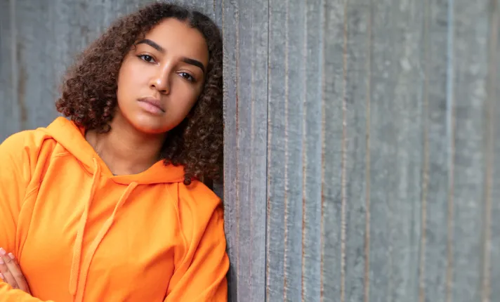 Niño apoyado en una pared