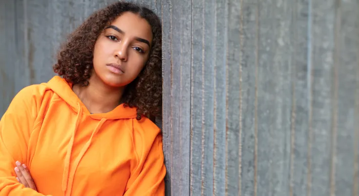 Niño apoyado en una pared