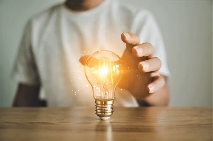 Hombre sujetando una bombilla simulando una idea