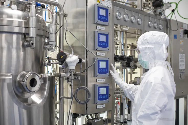 Científica operando equipos industriales en un laboratorio